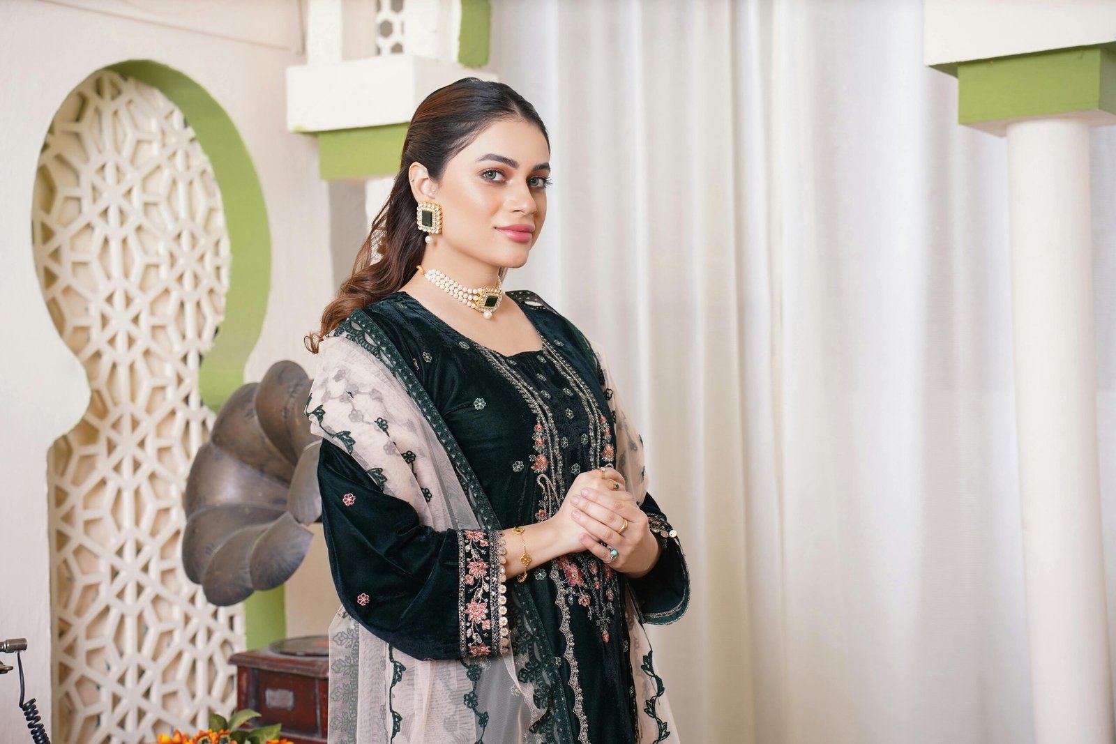 A fashion model in traditional attire, showcasing elegance and style indoors.